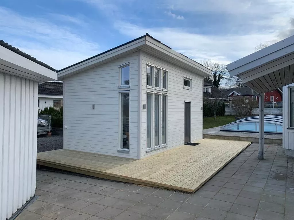 Modellen Älgen med mörk träfasad och stora glaspartier